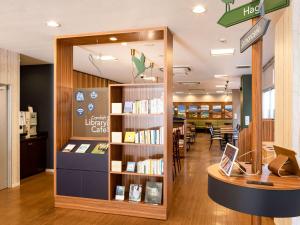 Comfort Hotel Shin Yamaguchi في ياماغوتشي: مكتبة بها رف للكتب