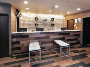 een lobby met een bar met 2 krukken bij Comfort Hotel Hakodate in Hakodate