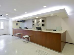 an office lobby with a reception desk and chairs at Comfort Hotel Kumamoto Shinshigai in Kumamoto