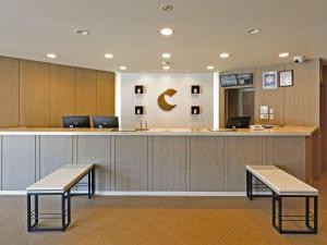 a waiting room with two benches and a counter at Comfort Hotel Kitami in Kitami