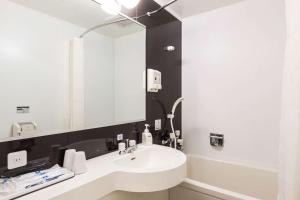a bathroom with a sink and a mirror at Comfort Hotel Kitami in Kitami
