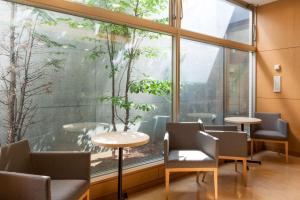 a room with a large window with chairs and a table at Comfort Hotel Kushiro in Kushiro