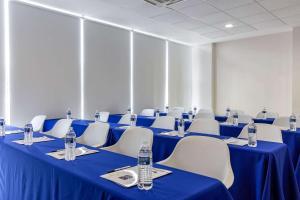 Sleep Inn Tijuana في تيخوانا: قاعة المؤتمرات مع الطاولات الزرقاء والكراسي البيضاء