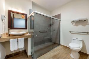 a bathroom with a shower and a toilet and a sink at Sleep Inn Tijuana in Tijuana