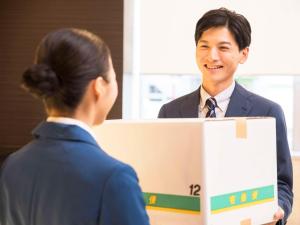 Un uomo in giacca e cravatta che parla con una donna di Comfort Hotel Wakayama a Wakayama