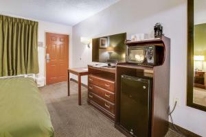a hotel room with a bed and a microwave at Quality Inn Fort Campbell-Oak Grove in Oak Grove