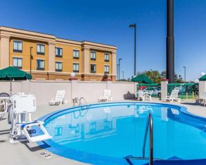 a large swimming pool with chairs and a building at Quality Inn Fort Campbell-Oak Grove in Oak Grove