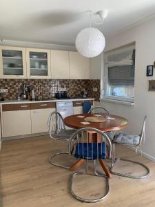 a kitchen with a table and chairs in a kitchen at Marika Vendégház in Szigetmonostor +14 photos