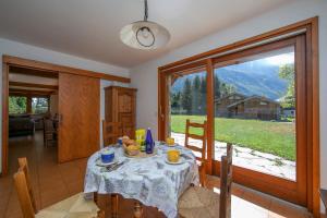 una sala da pranzo con tavolo e una grande finestra di Chalet du Golf 618 - Happy Rentals a Chamonix-Mont-Blanc