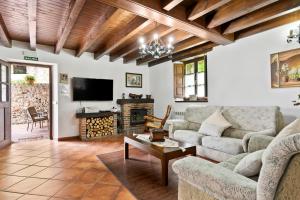 uma sala de estar com um sofá e uma televisão em Casa De Aldea La Venta Los Probes em Llanes
