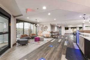 a large room with a living room and a dining room at Clarion Pointe Greensboro Airport in Greensboro