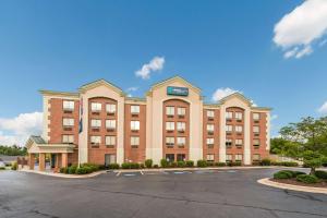 un gran edificio de ladrillo rojo con aparcamiento en Clarion Pointe Greensboro Airport, en Greensboro