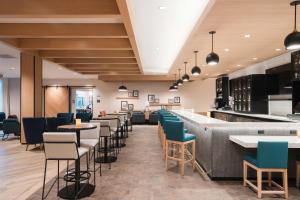 um restaurante com cadeiras e mesas e um bar em Hyatt House Sacramento Airport - Natomas em Sacramento