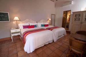 sypialnia z dużym białym łóżkiem z kolorowymi poduszkami w obiekcie Hotel Bantu by Faranda Boutique, a member of Radisson Individuals w mieście Cartagena de Indias