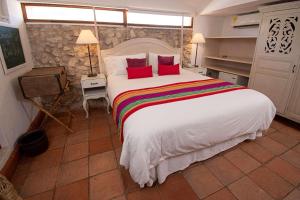 1 dormitorio con 1 cama blanca grande con almohadas rojas en Hotel Bantu by Faranda Boutique, a member of Radisson Individuals en Cartagena de Indias