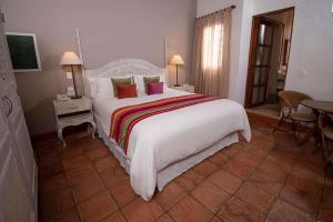 Un dormitorio con una gran cama blanca y una mesa en Hotel Bantu by Faranda Boutique, a member of Radisson Individuals en Cartagena de Indias