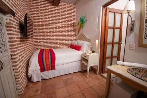 1 dormitorio con cama y pared de ladrillo en Hotel Bantu by Faranda Boutique, a member of Radisson Individuals en Cartagena de Indias