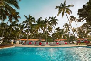 a swimming pool with lounge chairs and palm trees at Wyndham Alltra Samana All Inclusive Resort in Las Galeras