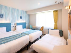 石垣島的住宿－Comfort Hotel Ishigaki Island，酒店客房设有两张床和窗户。