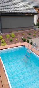 a swimming pool with a chair in front of a house at ,,Domek Na Skarpie'' z Balią i basenem letnim in Sulęczyno