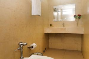 W łazience znajduje się umywalka, toaleta i lustro. w obiekcie Hotel Faranda Express Soloy and Casino, a member of Radisson Individuals w Panamie