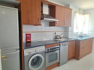 a kitchen with a washing machine and a sink at Casa Feliz - Stunning 2 bed Penthouse in Manilva with pool, sea and mountain views, close to the beach and facilities in Manilva