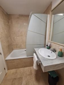 a bathroom with a sink and a bath tub at Casa Feliz - Stunning 2 bed Penthouse in Manilva with pool, sea and mountain views, close to the beach and facilities in Manilva