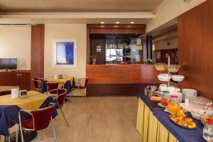 restauracja z dwoma stołami i bar w tle w obiekcie Hotel Mariani w mieście Jesi