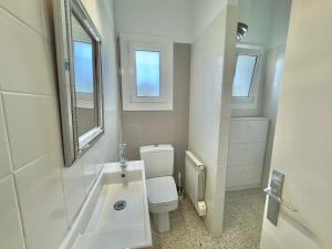 a bathroom with a toilet and a sink and a mirror at Casita Bouganvilla in Roses +24 photos