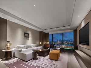 a living room with a white couch and a large window at Hilton Changshu in Changshu