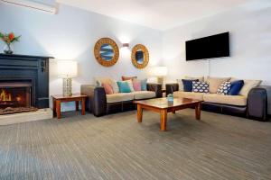 sala de estar con 2 sofás y chimenea en Comfort Resort Waters Edge, en Port Macquarie