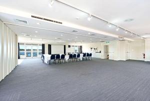 uma grande sala com cadeiras e mesas em Comfort Resort Waters Edge em Port Macquarie