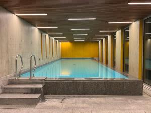 a large swimming pool in a building with stairs at Room Casa Jessika in Orselina