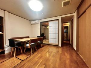 a dining room with a wooden table and chairs at Kyoto Nijo Guest House HoshiIke villa in Kyoto