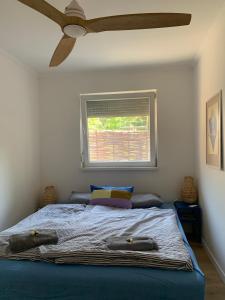 a bedroom with a bed with a ceiling fan at Marika Vendégház in Szigetmonostor