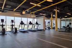 a gym with rows of treadmills and exercise bikes at First Class 1BR Apartment in Dubai Hills - next to Dubai Hills Mall in Dubai