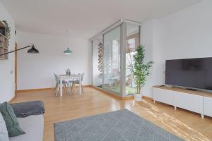 a living room with a couch and a tv and a table at GuestReady - Sant Adrià de Besòs Hideaway in Barcelona