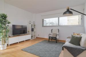 a living room with a couch and a flat screen tv at GuestReady - Sant Adrià de Besòs Hideaway in Barcelona