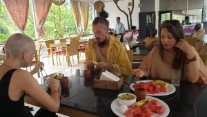 a group of people sitting at a table eating food at Hiranya Nature Retreat in Daulatābād