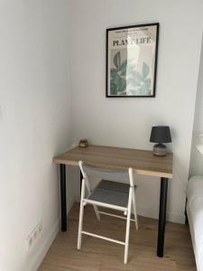 uma secretária de madeira com uma cadeira e um candeeiro em GuestReady - Stylish Haven in Downtown Bordeaux em Bordeaux