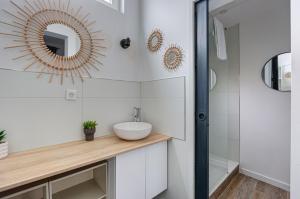 uma casa de banho com um lavatório e um espelho em GuestReady - Stylish Haven in Downtown Bordeaux em Bordeaux