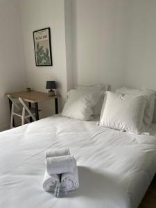 uma cama branca com uma toalha em cima em GuestReady - Stylish Haven in Downtown Bordeaux em Bordeaux