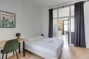 um quarto com uma cama, uma secretária e uma janela em GuestReady - Stylish Haven in Downtown Bordeaux em Bordeaux