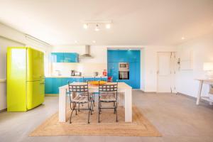 a kitchen with blue cabinets and a table and chairs at GuestReady - Oasis Retreat in Tróia in Troia