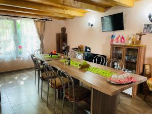 a dining room with a large wooden table and chairs at Balla House in Tărcaia