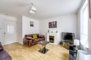 爱丁堡GuestReady - A Pleasant Stay near Leith的客厅里有一张沙发和一台电视