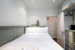 una piccola camera con un letto bianco di GuestReady - Petite Perfection near Battersea Park a Londra