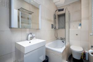 łazienka z umywalką, toaletą i wanną w obiekcie GuestReady - Petite Perfection near Battersea Park w Londynie