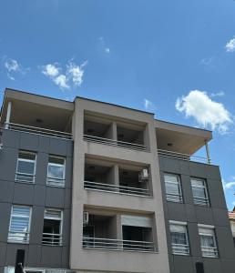un immeuble d'appartements avec un ciel bleu en arrière-plan dans l'établissement Apartman City Center 1-šetalište, à Prijedor
