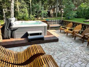 Villa Borovets Mountain & Luxury في بوروفتس: يوجد حوض استحمام ساخن على فناء مع مقاعد